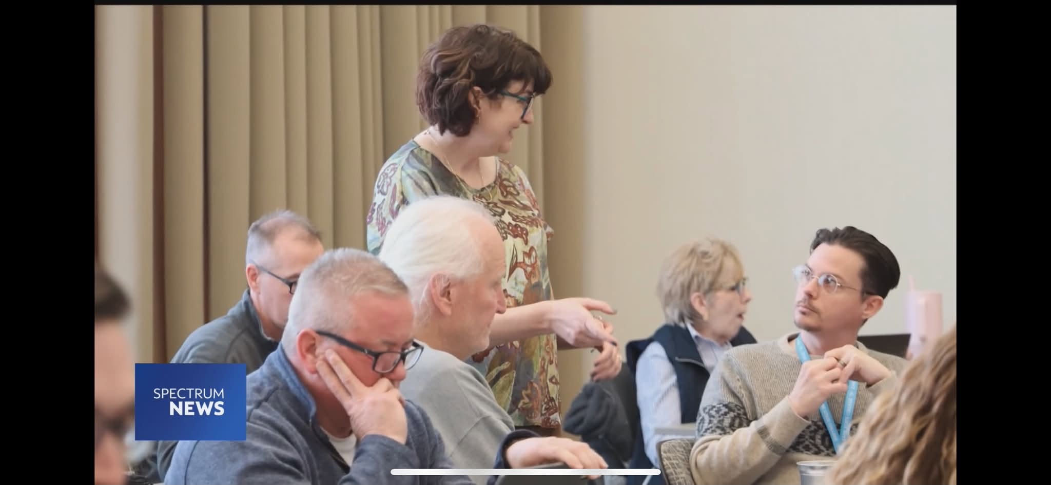 Dr. Jen Lisy leading a discussion with workshop participants, filmed for Spectrum News 1